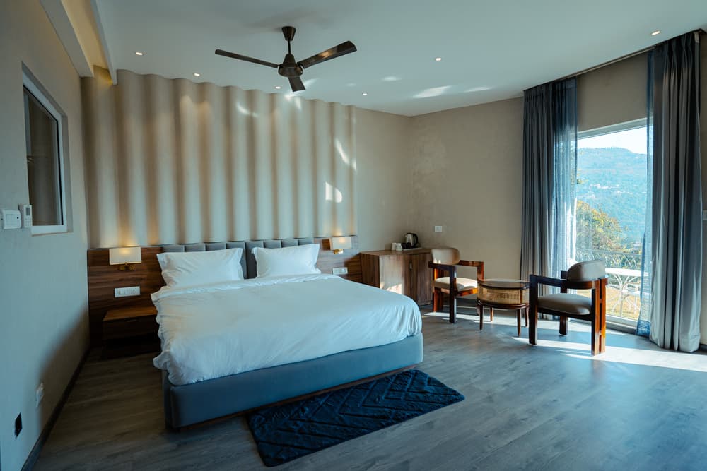 A Mountain View Suite with a floor-to-ceiling window onto the Kumaon ridgelines